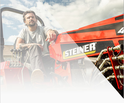 man sitting behind the steering wheel of a Steiner 450 tractor